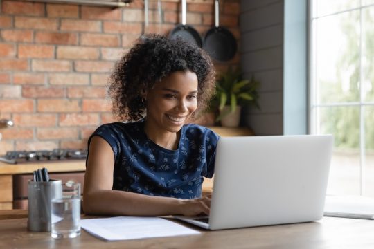 Smiling woman looking at her laptop