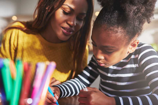 Mother and daughter do colouring in