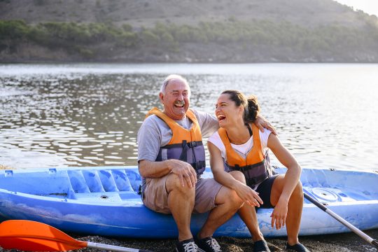 Father and daughter sitting on kayak